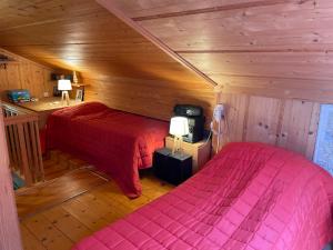 a bedroom with two beds in a wooden cabin at Le Reposoir in La Comballaz