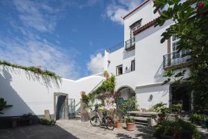 Biały budynek z rowerem zaparkowanym przed nim w obiekcie Solar de Santo André w mieście Ponta Delgada