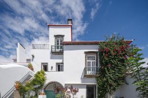 蓬塔德尔加达Solar de Santo André的白色的建筑,花朵在建筑的一侧