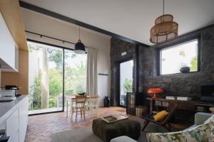 cocina y sala de estar con pared de piedra en Solar de Santo André, en Ponta Delgada