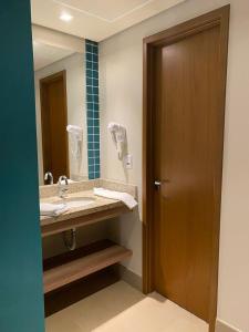 a bathroom with a sink and a mirror at Resort Solar das Águas in Olímpia