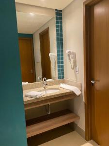 a bathroom with a sink and a mirror at Resort Solar das Águas in Olímpia