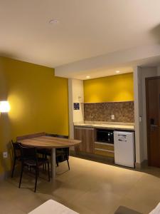 a kitchen with a table and a kitchen with yellow walls at Resort Solar das Águas in Olímpia