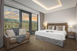 فندق رويال براغ في براغ: غرفة نوم بسرير وكرسي ونافذة