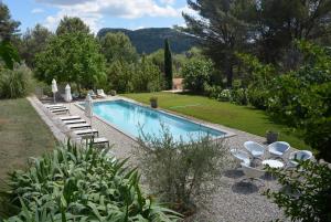 a swimming pool with lounge chairs and a garden at Les Aludes in La Destrousse