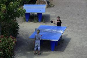two children standing next to a ping pong table at Terres de France - Les Hameaux de Miel in Beynat