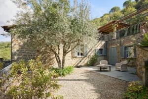 een stenen huis met een boom en een patio bij Villa Bobolino in Cortona