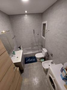 a bathroom with a tub and a toilet and a sink at Sky Apartment 1 in St Paul's Bay