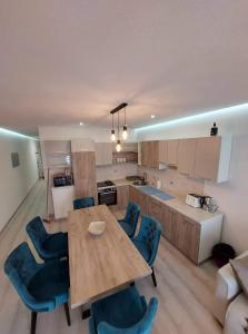 una cucina con tavolo in legno e sedie blu di Sky Apartment 1 a San Pawl il-Baħar