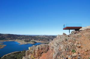 a building on the side of a mountain with a body of water at Hoteles Desconecta2 in Monesterio