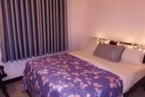 1 dormitorio con 1 cama con manta morada en Lakeville Residence en Nuwara Eliya