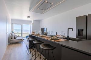 een keuken met een aanrecht met krukken bij Cozy apartment with beautiful seaview in Knokke-Heist