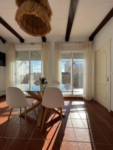 Un comedor con una mesa y sillas blancas. en BALCÓN DE CLAUDIO MARCELO, en Córdoba