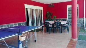 uma sala de jantar com uma mesa de pingue-pongue e paredes vermelhas em 5 bedrooms villa with private pool enclosed garden and wifi at Ubriquea em Ubrique