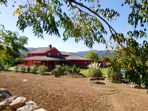 a red house with a garden in front of it at 5 bedrooms villa with private pool enclosed garden and wifi at Ubriquea in Ubrique