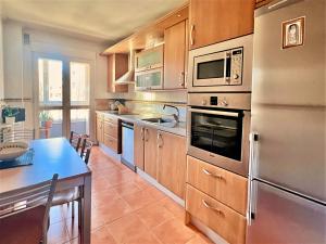 cocina con electrodomésticos de acero inoxidable y mesa en Housingleon- Casa Oliva con Garaje en León