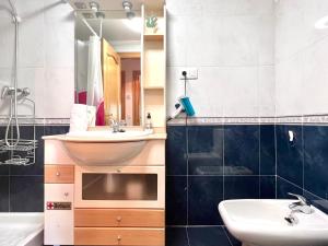 a bathroom with a sink and a mirror at Housingleon- Casa Oliva con Garaje in León