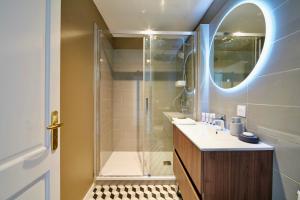 a bathroom with a shower and a sink and a mirror at La Petite Adresse du 10Honfleur in Honfleur