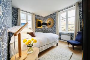 ein Schlafzimmer mit einem Bett mit blauen und weißen Tapeten in der Unterkunft La Petite Adresse du 10Honfleur in Honfleur