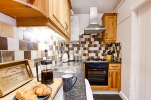 eine Küche mit einer Theke mit etwas Brot drauf in der Unterkunft Woodbury Cottage in Woodbury