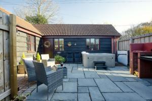 a patio with chairs and a tub in a backyard at Woodbury Cottage in Woodbury