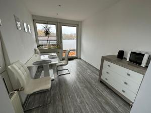 a living room with a table and chairs and a microwave at Pension am Teutoburger Wald in Georgsmarienhütte
