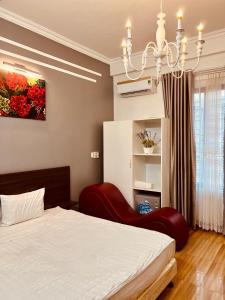 1 dormitorio con cama y lámpara de araña en Mộc Hương Hotel, en Phú Thọ