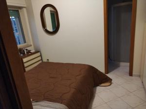 sypialnia z łóżkiem i lustrem na ścianie w obiekcie Appartamento Correale w mieście Napoli