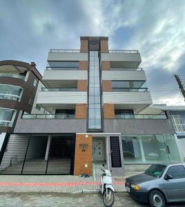 a building with a scooter parked in front of it at Apto mobiliado em Balneário Piçarras 100 m do mar in Piçarras