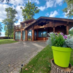 a log home with a green flower pot in front of it at Lauviņu rezidence in Kocēni