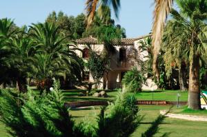 ein Haus mit Palmen davor in der Unterkunft Residence Baia delle Palme in Pula