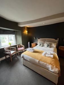 a bedroom with a large bed in a room at The Kings Arms in Didmarton