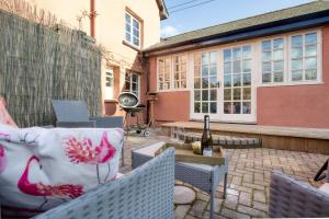 een patio met stoelen en een fles wijn bij White Cross Cottage in Woodbury