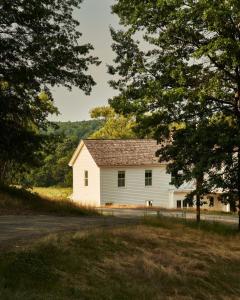 a white house with trees on the side of a road at Inness in Accord