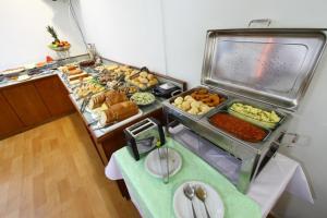 um buffet com muitos tipos diferentes de comida em uma mesa em Cerrados Park Hotel em Várzea Grande