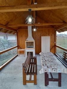 Podu CoşniiにあるCabana Irissの小屋の中にストーブとベンチがある部屋