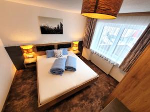 1 dormitorio con 1 cama blanca y 2 almohadas azules en Apart Garni Jägerheim, en Kappl