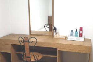 a wooden desk with a mirror and a pair of scissors at Annie House in Busan