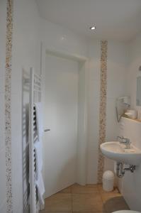 een witte badkamer met een wastafel en een toilet bij Landhaus Kaiser in Abenberg