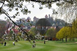 people playing in a park with a castle in the background at Landhaus Kaiser in Abenberg