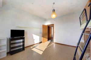 uma sala de estar com uma escada e uma televisão em Casa Fronte mare em Arma di Taggia