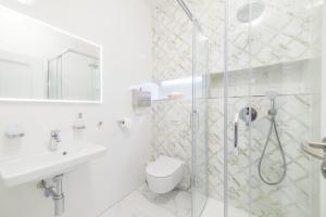 a white bathroom with a shower and a toilet at Salón MISSEN in Omšenie