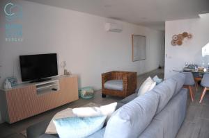 a living room with a couch and a tv at Mar à Vista Burgau in Burgau