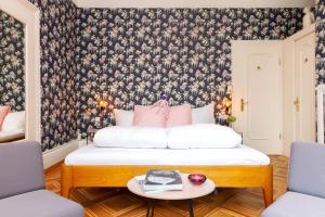 a bedroom with a bed with a floral wallpaper at Hotel Beau Séjour Lucerne in Lucerne