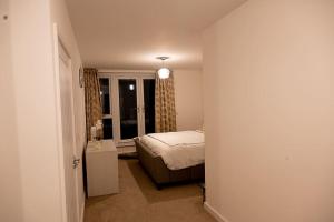 a small bedroom with a bed and a window at Exquisite cozy house, close to Train Station and amenities in Harold Wood