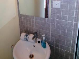 a bathroom with a white sink and blue tiles at Afro Beach Eco Resort Butre in Butre