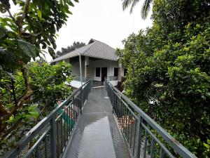 Ein Gehweg führt zu einem Haus mit einem Zaun. in der Unterkunft Munnar Home stay in Munnar