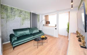 a living room with a green couch and a table at One by One - by Grand Accommodation in Bucharest