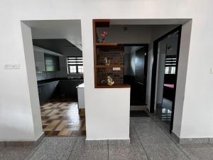 a kitchen with white walls and a counter in a room at Munnar Home stay in Munnar