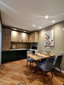 ein Esszimmer mit einem Tisch und Stühlen sowie eine Küche in der Unterkunft XIO Apartments in Bar